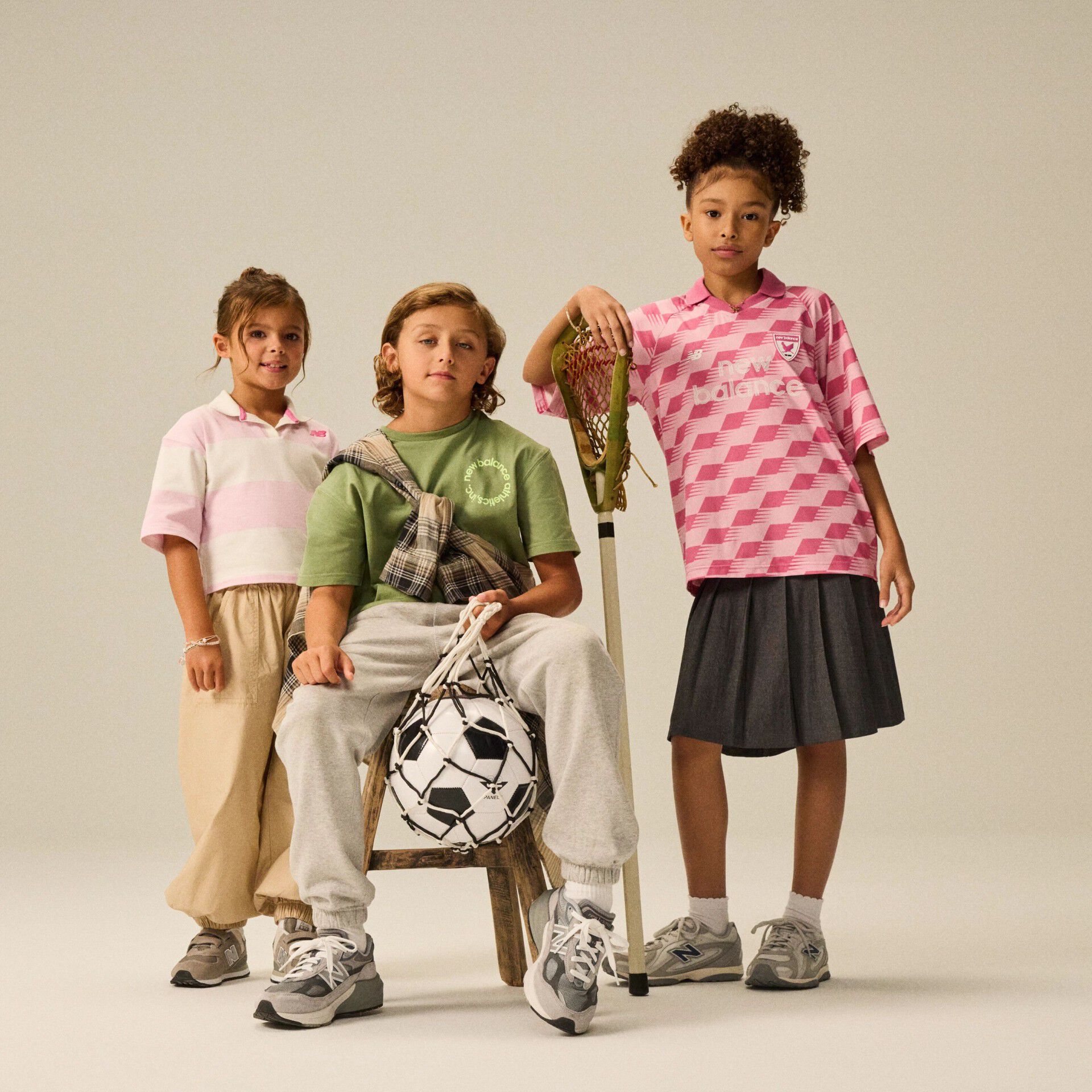 Group of kids in front of a beige background. 