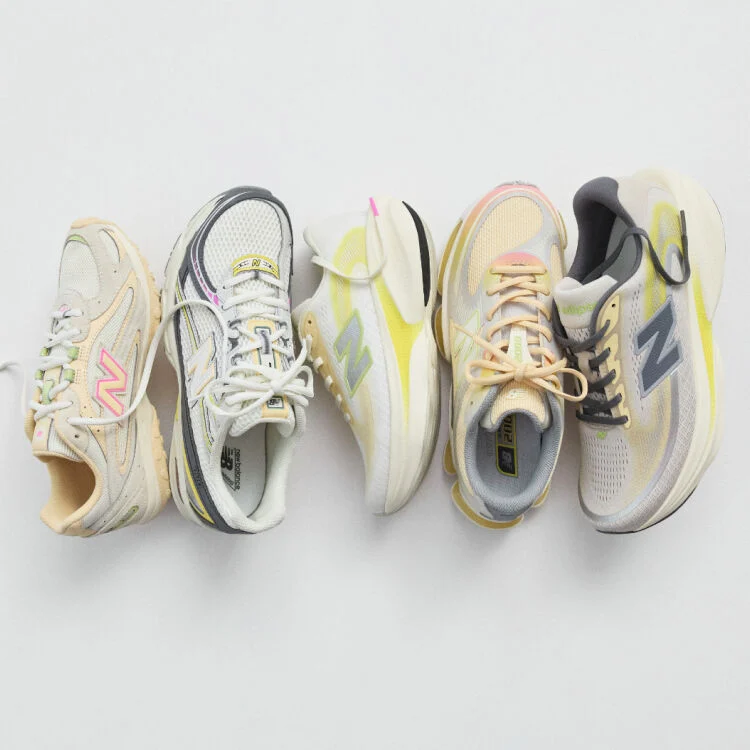 A pair of New Balance Made in UK sneakers in a brown textured studio environment. 