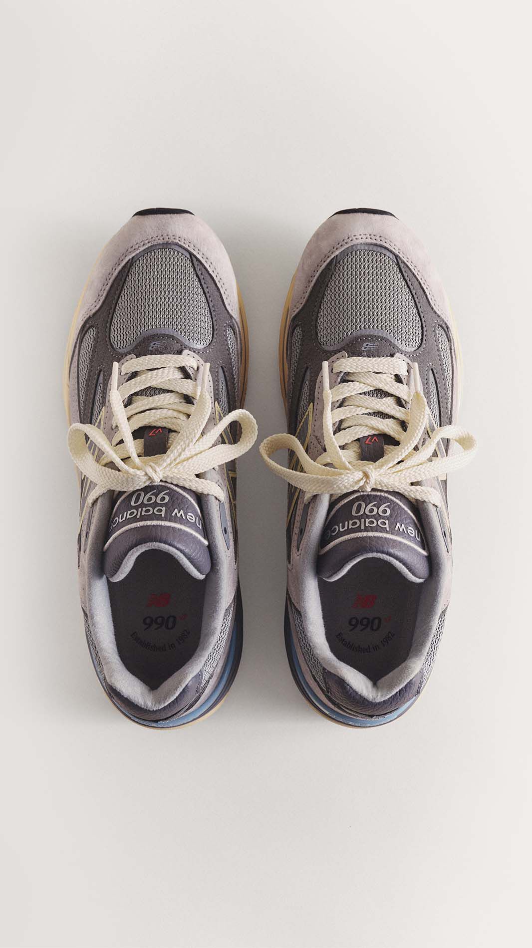 A top down image of a pair of grey 990v7 sneakers.