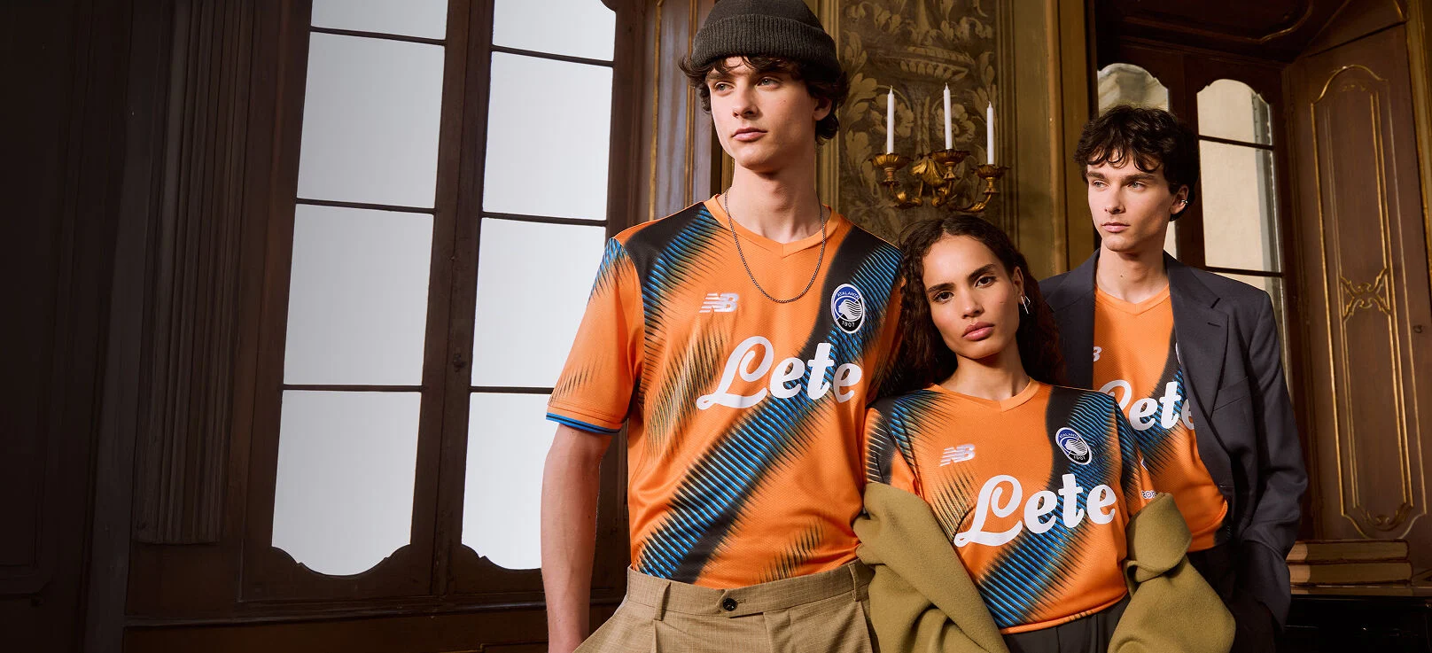 Three models wearing orange Atalanta jerseys    