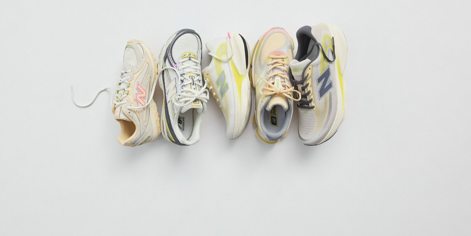 A pair of New Balance Made in UK sneakers in a brown textured studio environment. 